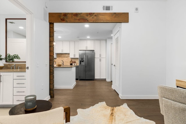 kitchen featuring tasteful backsplash, white cabinetry, dark hardwood / wood-style floors, and stainless steel fridge with ice dispenser