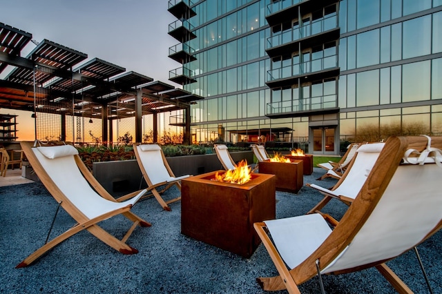 patio terrace at dusk featuring an outdoor fire pit