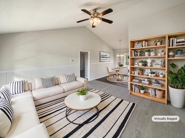 living room featuring ceiling fan with notable chandelier, vaulted ceiling, and a textured ceiling