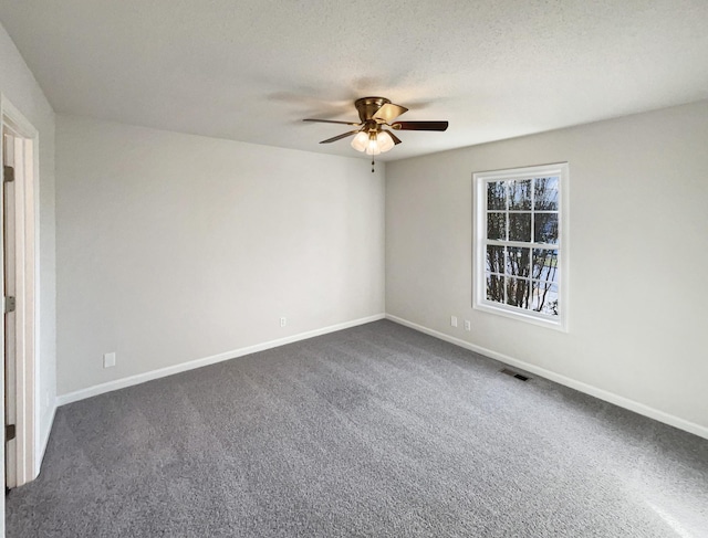 carpeted spare room with a textured ceiling and ceiling fan