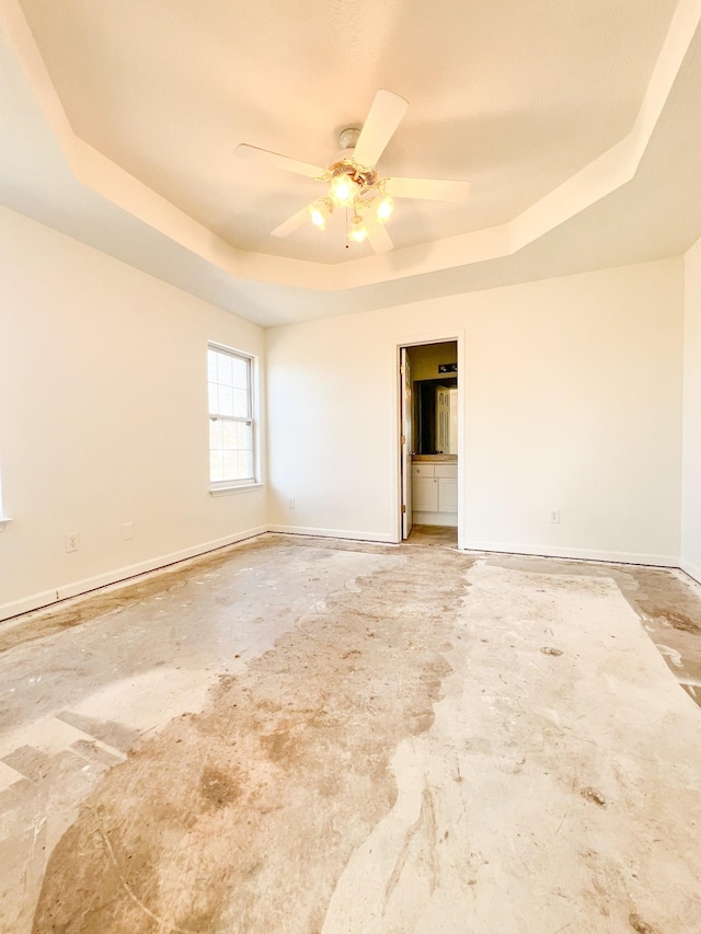 unfurnished room featuring a raised ceiling and ceiling fan