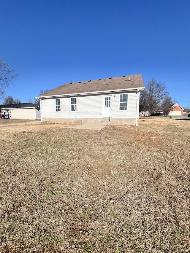 back of house with a patio and a lawn