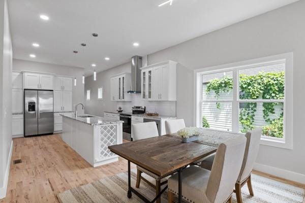 dining space with recessed lighting, light wood-type flooring, and baseboards