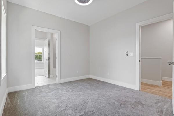 spare room featuring baseboards and carpet