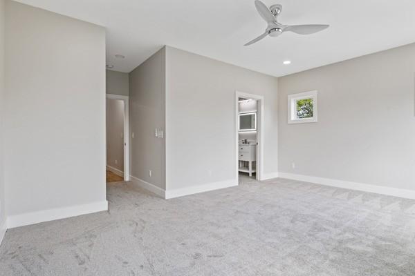 empty room featuring baseboards, carpet floors, and ceiling fan