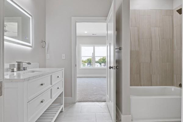 bathroom with tile patterned floors, shower / washtub combination, vanity, and baseboards