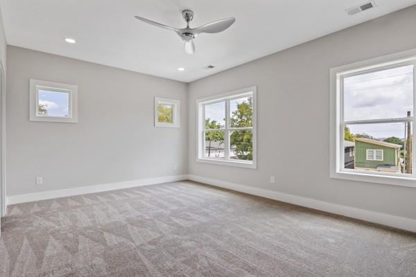 carpeted empty room featuring recessed lighting, visible vents, baseboards, and a ceiling fan