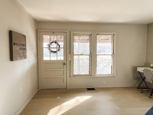 doorway to outside with visible vents, baseboards, and wood finished floors