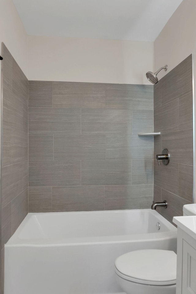 full bathroom with vanity, tiled shower / bath, and toilet