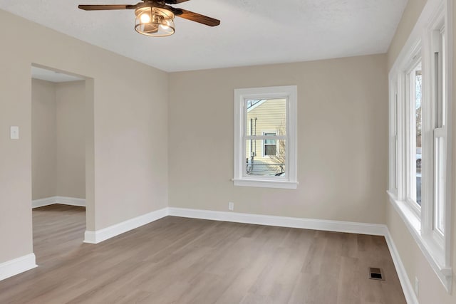 unfurnished room with a textured ceiling, light hardwood / wood-style flooring, and ceiling fan