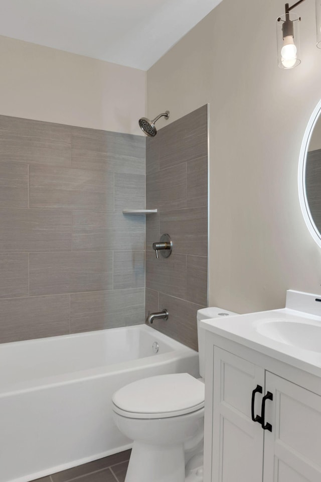 full bathroom featuring vanity, toilet, tiled shower / bath combo, and tile patterned flooring