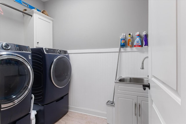 laundry area with cabinets, sink, light tile patterned floors, and washer and clothes dryer