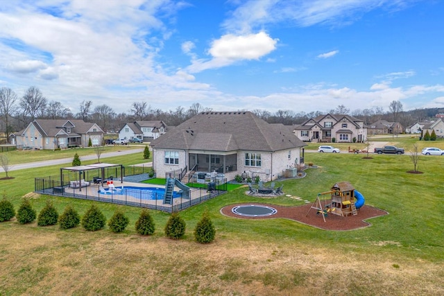 view of swimming pool with a playground, a sunroom, and a lawn