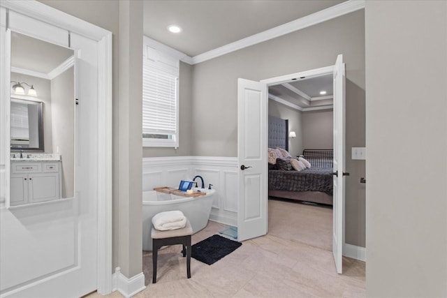 bathroom with vanity, crown molding, and a bathing tub