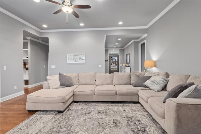 living room with crown molding, hardwood / wood-style floors, and ceiling fan