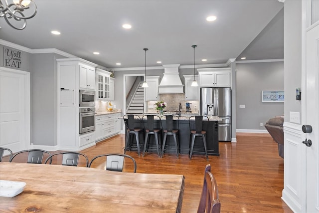 dining area featuring dark wood-type flooring, ornamental molding, and sink