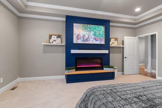 carpeted bedroom with a raised ceiling, ornamental molding, and a fireplace