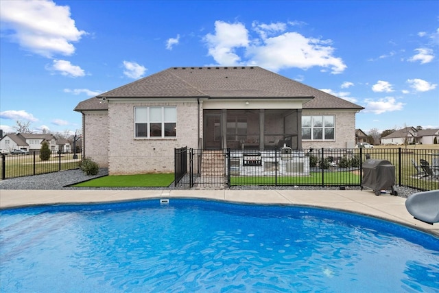 view of swimming pool with a grill, a patio area, and a sunroom