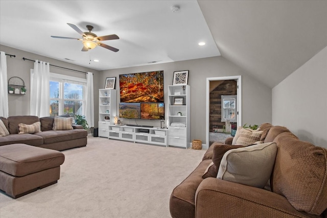 living room with ceiling fan, lofted ceiling, and light carpet