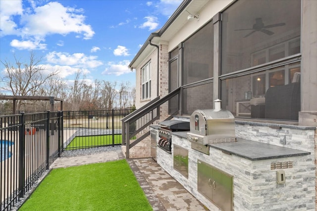 view of yard with area for grilling and ceiling fan