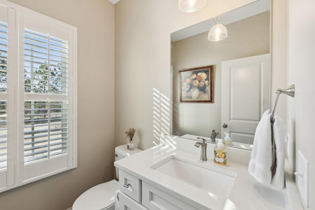 bathroom with vanity, a healthy amount of sunlight, and toilet