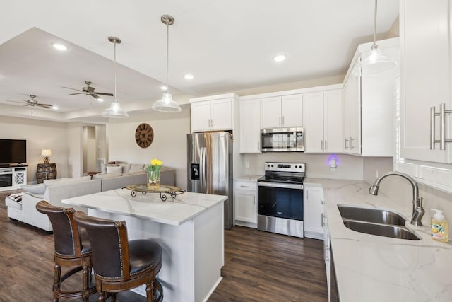 kitchen with appliances with stainless steel finishes, decorative light fixtures, sink, and white cabinets