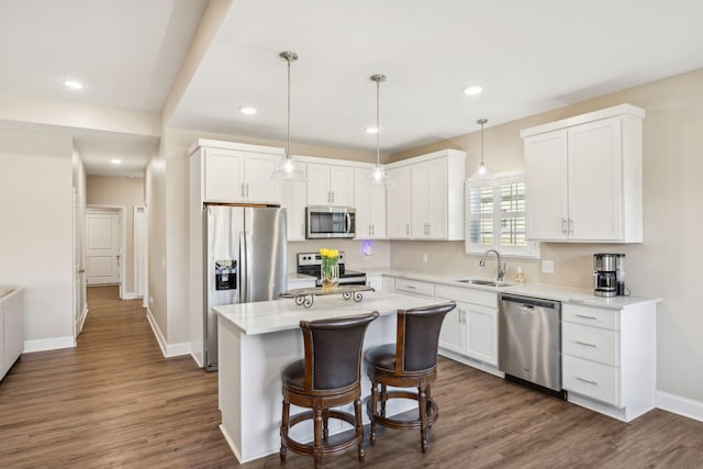 kitchen with sink, stainless steel appliances, a center island, and white cabinets