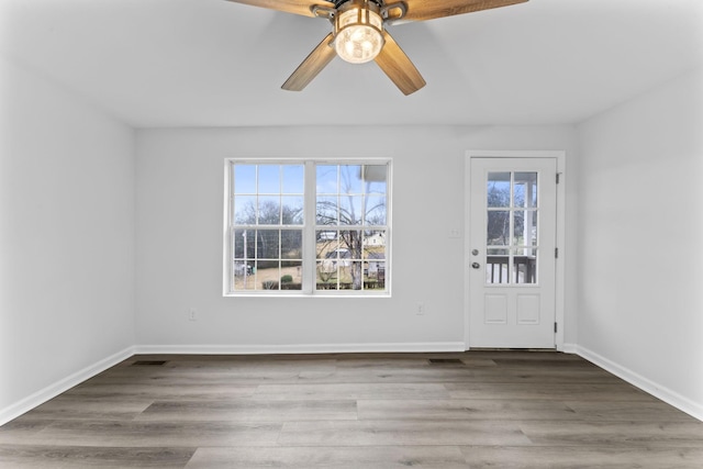 empty room featuring hardwood / wood-style flooring, ceiling fan, and a wealth of natural light