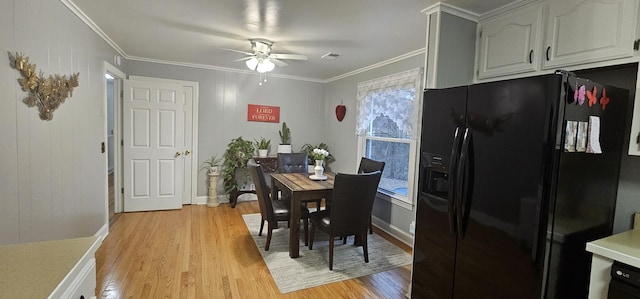 dining area with ceiling fan, ornamental molding, and light wood-type flooring