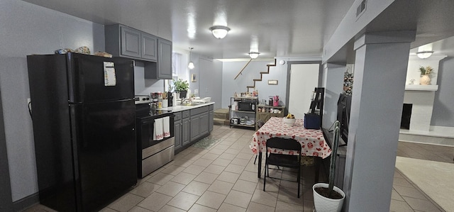 kitchen with gray cabinets, light tile patterned floors, and black appliances