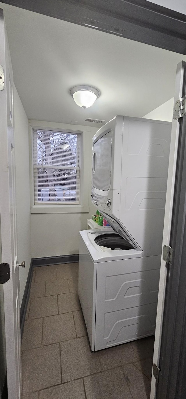 clothes washing area featuring stacked washer / drying machine