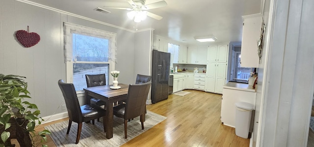 dining room featuring crown molding, light hardwood / wood-style floors, and ceiling fan