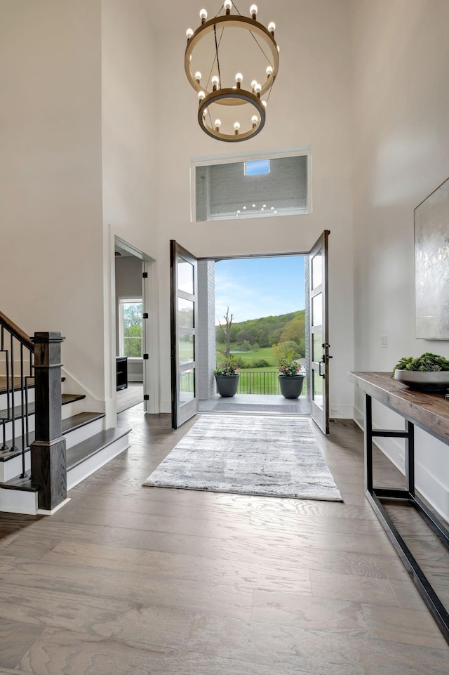 entryway featuring a wealth of natural light, hardwood / wood-style floors, and a notable chandelier