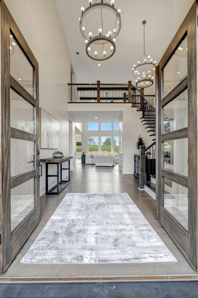 interior space with dark hardwood / wood-style floors, a chandelier, and a high ceiling