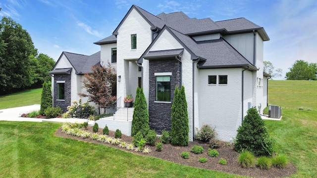 view of front of house with central AC and a front yard