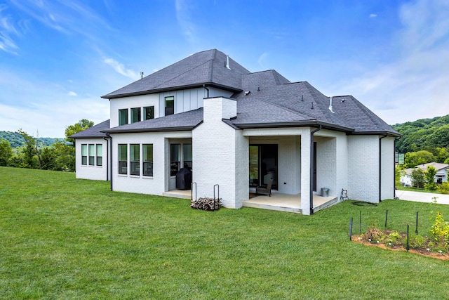 back of property with a lawn and a patio