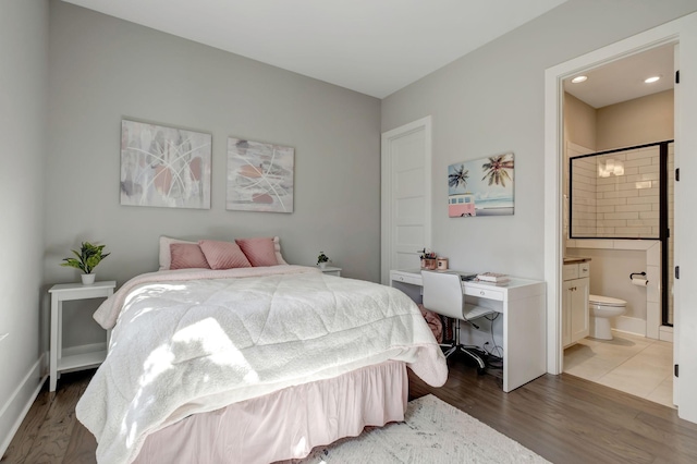 bedroom featuring ensuite bathroom and dark hardwood / wood-style floors