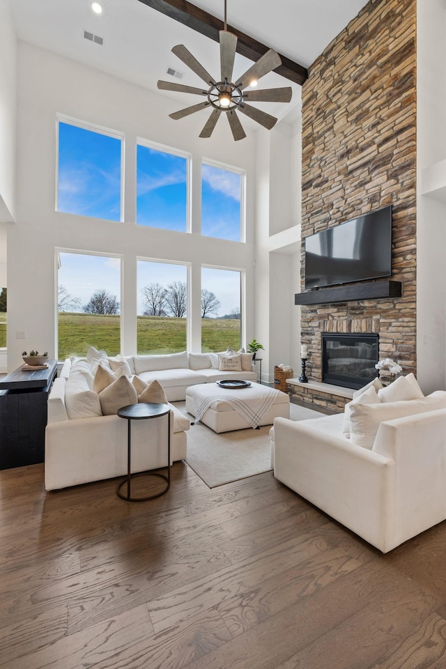 living room with beamed ceiling, ceiling fan, hardwood / wood-style floors, and a fireplace