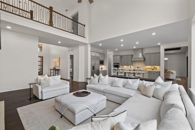 living room featuring a towering ceiling and dark hardwood / wood-style flooring