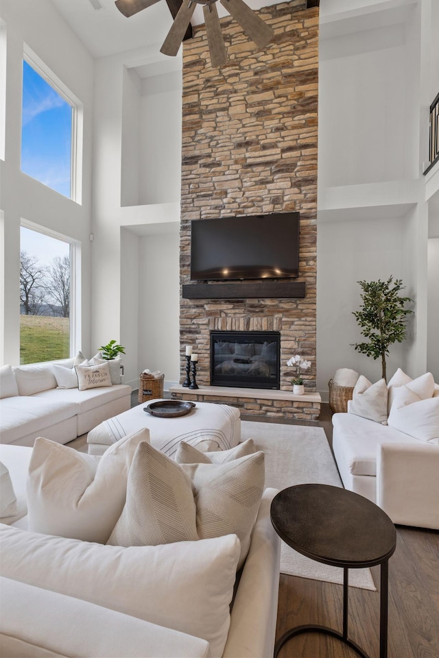 living room featuring a fireplace, hardwood / wood-style floors, and a high ceiling