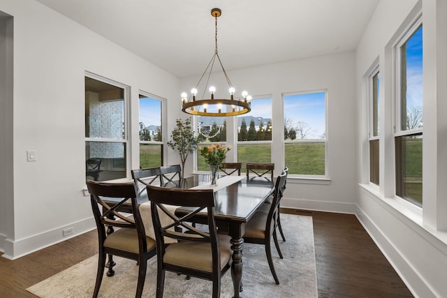 dining room featuring an inviting chandelier, a healthy amount of sunlight, and dark hardwood / wood-style floors