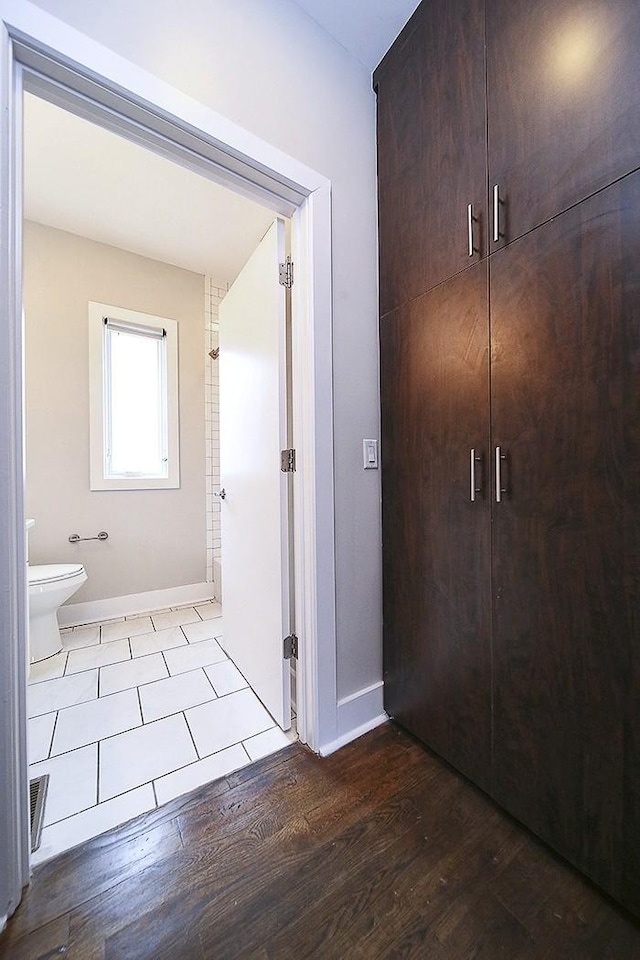 bathroom featuring hardwood / wood-style flooring and toilet