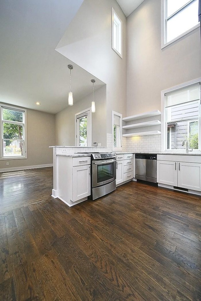 kitchen with white cabinetry, hanging light fixtures, stainless steel appliances, tasteful backsplash, and kitchen peninsula