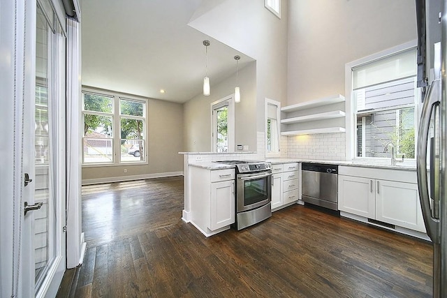 kitchen with stainless steel appliances, white cabinetry, pendant lighting, and kitchen peninsula