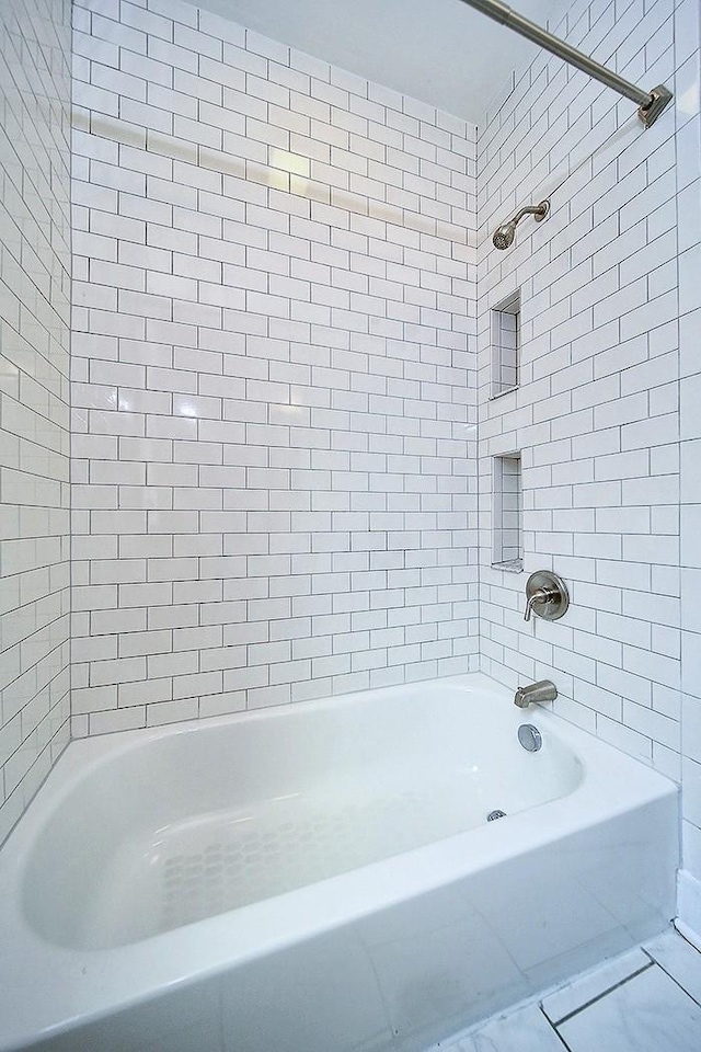 bathroom with tiled shower / bath combo and tile patterned floors