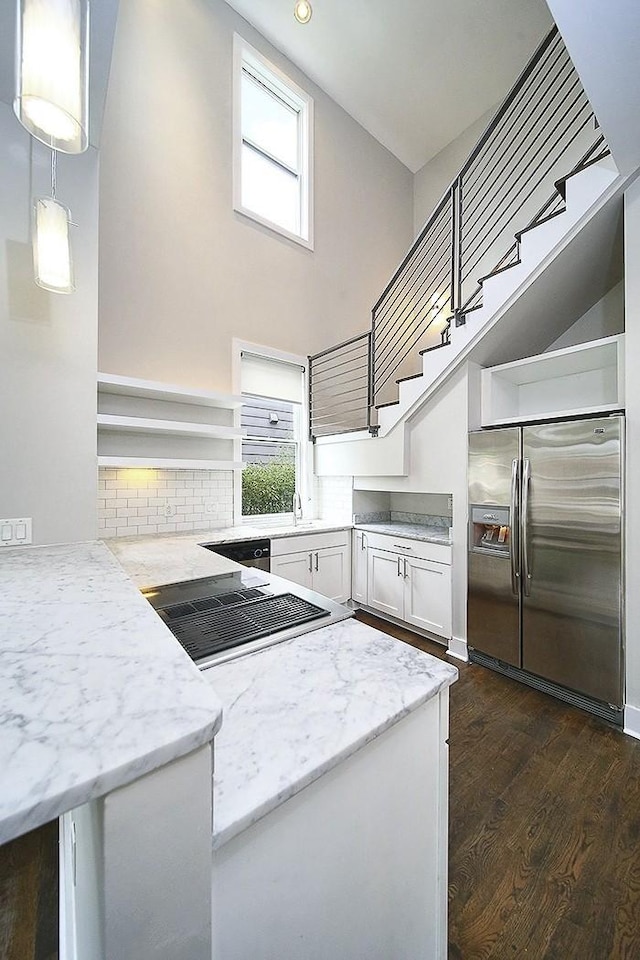 kitchen featuring decorative light fixtures, white cabinetry, light stone counters, stainless steel fridge with ice dispenser, and dark wood-type flooring