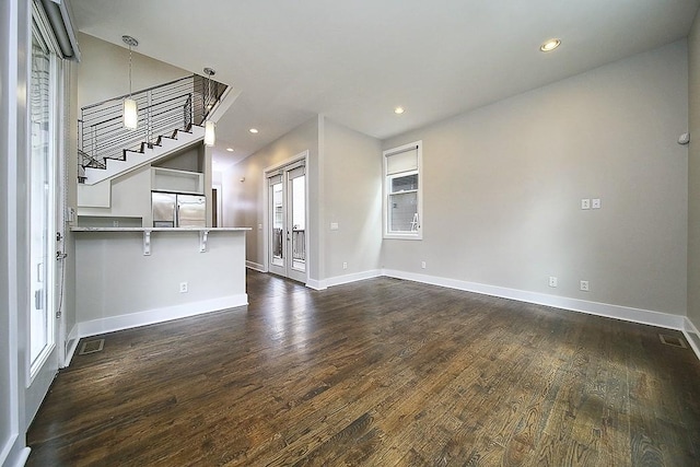 unfurnished living room with dark hardwood / wood-style flooring and french doors