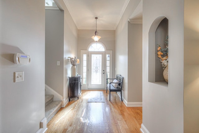 foyer with crown molding, plenty of natural light, and light wood-type flooring