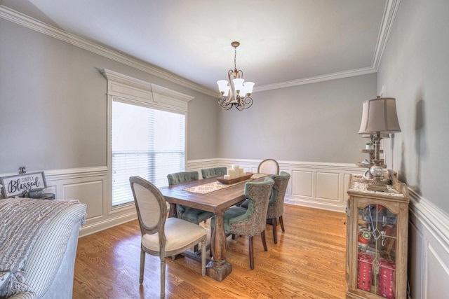 dining room with crown molding, a notable chandelier, and light hardwood / wood-style floors