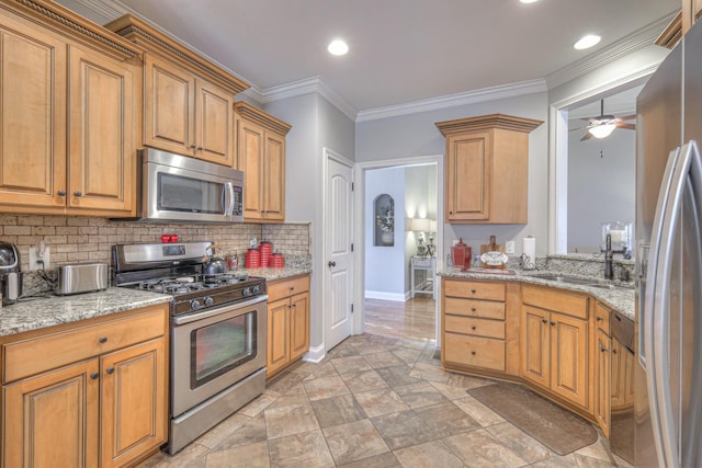 kitchen with sink, crown molding, appliances with stainless steel finishes, light stone countertops, and decorative backsplash